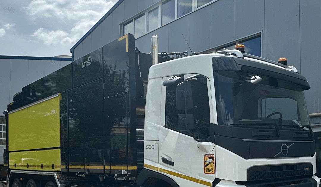 شاحنة MTS صفراء مع نظام شفط متطور أمام المصنع الرئيسي في ألمانيا، مخصصة لأعمال الحفر غير الهدمي في مشاريع البنية التحتية والسكك الحديدية.