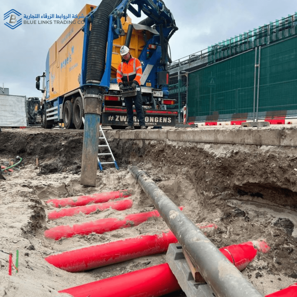 Worker operating a suction excavator hose to remove soil safely during non-destructive digging.