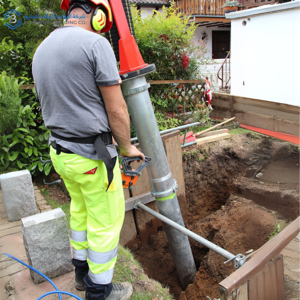 Construction worker manually guiding a suction excavator nozzle for safe ground excavation.